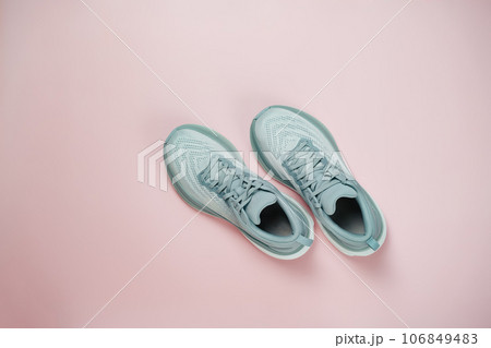 New light blue green female modern running shoe on pink background. Stylish monochrome shoes for active people that incorporate new health technology. Top view 106849483