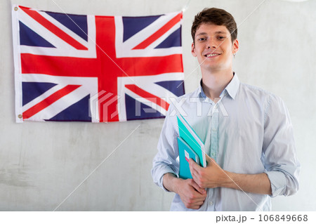 Male student with notebooks in his hands against background of the UK flag 106849668