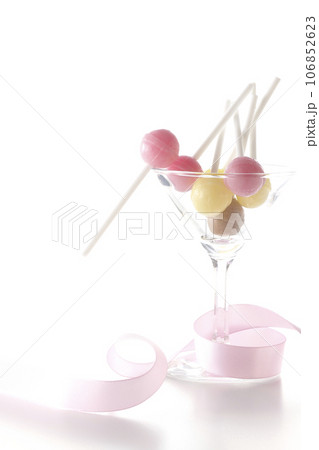 カクテルグラスとキャンディとリボンを白背景で撮影 カクテルグラスとキャンディとリボンを白背景で撮影 106852623