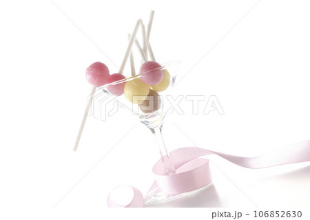 カクテルグラスとキャンディとリボンを白背景で撮影 106852630