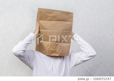An anonymous man with a box on his head, constricting his identity. Hidden emotions. An anonymous man with a box on his head, constricting his identity. Hidden emotions. 106855247