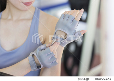 スポーツジムでトレーニンググローブをする若い女性 スポーツジムでトレーニンググローブをする若い女性 106855323