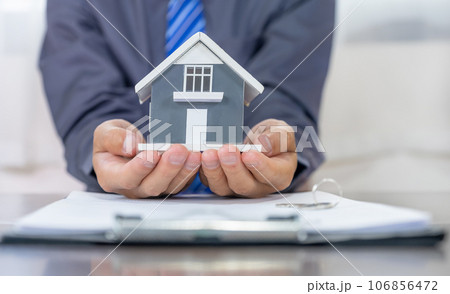 Real estate agents holding home model, explains the business contract for signing a business contract, renting, buying, mortgage, loan or home insurance 106856472