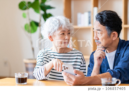 スマートフォンを一緒に見るシニア夫婦。 スマートフォンを一緒に見るシニア夫婦。 106857405