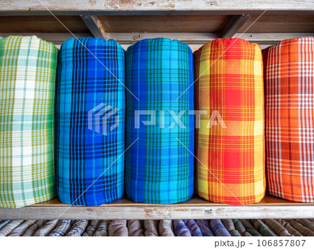The handmade woven silk rolls with the plaid pattern. 106857807