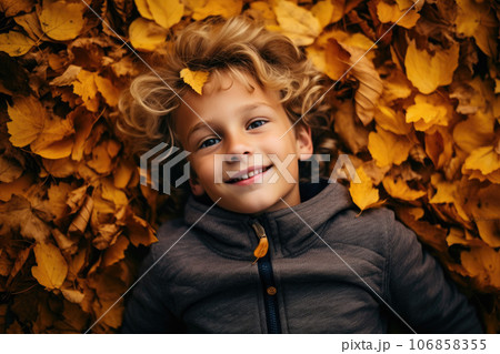 The boy lies in the autumn leaves 106858355
