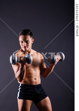 Shirtless bodybuilder showing his great body and holding dumbell. Shirtless bodybuilder showing his great body and holding dumbell. 106859169