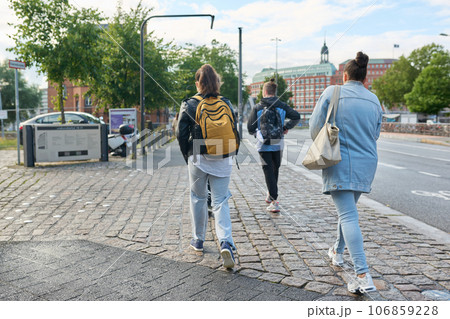 Back view of people walking along the street of a modern city Back view of people walking along the street of a modern city 106859228