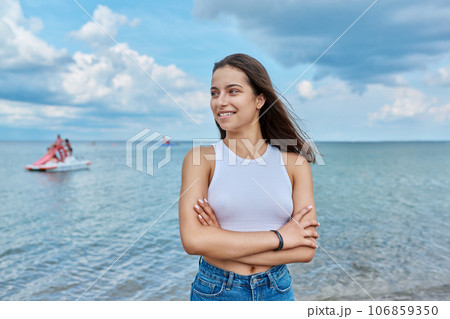 Portrait of smiling teenage girl outdoor on sea background 106859350