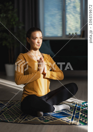 Woman relaxing at home doing yoga Woman relaxing at home doing yoga 106859672