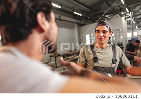 Two carpenters working together at a workshop Two carpenters working together at a workshop 106860111