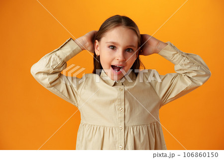 Surprised teenage girl over yellow background in studio 106860150