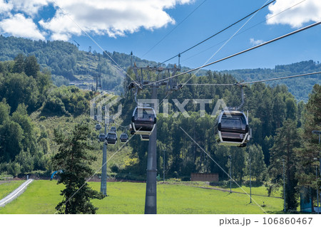 Close-up of a cable car cabin against the sky. Cable car trip to viewpoints in the mountains. During the trip by cable car Tourists enjoy beautiful views and experience exciting. Close-up of a cable car cabin against the sky. Cable car trip to viewpoints in the mountains. During the trip by cable car Tourists enjoy beautiful views and experience exciting. 106860467
