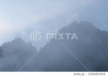 Mountains and peaks in fog at sunrise or sunset. Sun from behind the mountain. Amazing view of mountains and forest landscape with cloudy skies Altai mountains. Mountains and peaks in fog at sunrise Mountains and peaks in fog at sunrise or sunset. Sun from behind the mountain. Amazing view of mountains and forest landscape with cloudy skies Altai mountains. Mountains and peaks in fog at sunrise 106860568