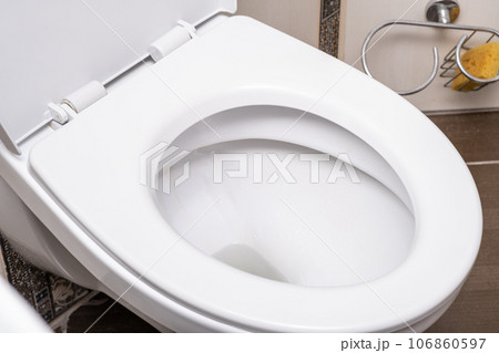White toilet bowl in the toilet in the bathroom. The toilet before it is washed. The concept of cleaning and cleanliness. 106860597