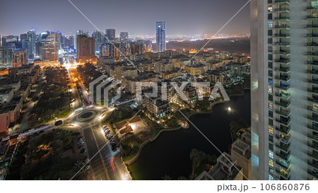 Panorama showing skyscrapers in Barsha Heights district and low rise buildings in Greens district aerial night timelapse. Panorama showing skyscrapers in Barsha Heights district and low rise buildings in Greens district aerial night timelapse. 106860876
