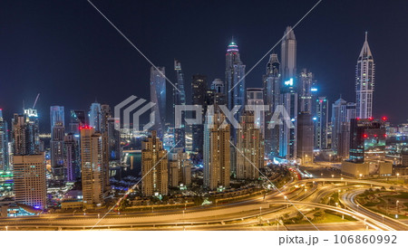 Skyscrapers of Dubai Marina near intersection on Sheikh Zayed Road with highest residential buildings all night timelapse Skyscrapers of Dubai Marina near intersection on Sheikh Zayed Road with highest residential buildings all night timelapse 106860992