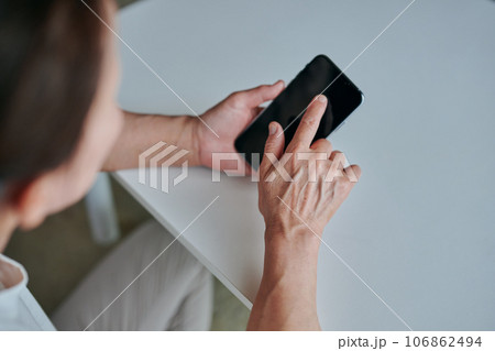部屋でスマホを操作するシニア女性 部屋でスマホを操作するシニア女性 106862494
