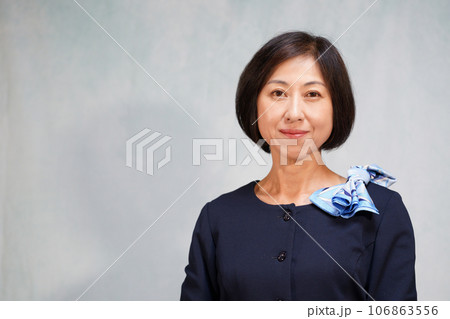襟元にスカーフのリボンを付けた笑顔の中年女性 106863556