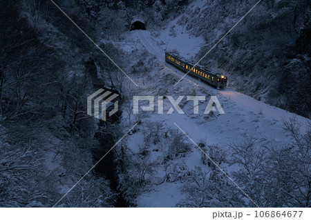 新潟県小千谷市・JR飯山線　夕暮れの雪の谷を走る単行列車 106864677
