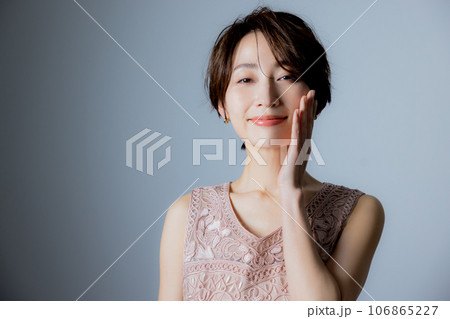 頬に手を当てる笑顔の女性 106865227