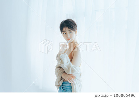 朝日を浴びて外を眺める女性 106865496