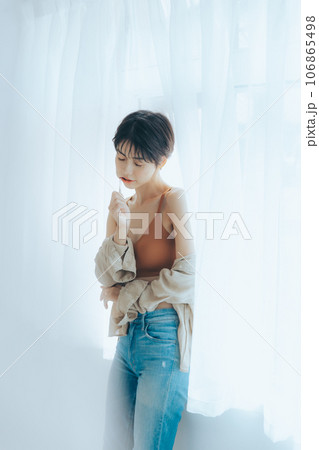 朝日を浴びて外を眺める女性 106865498
