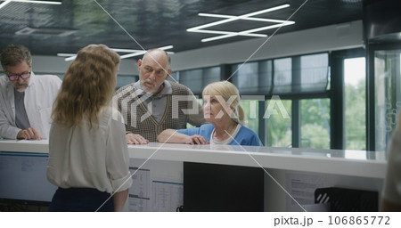 Elderly couple stand near reception desk in clinic 106865772
