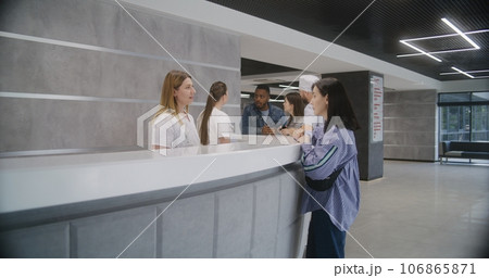 Adult woman stands at reception desk in clinic 106865871