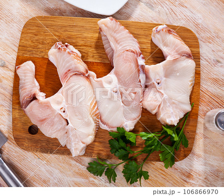 Uncooked tiger shark fillet fish with parsley and lemon on table 106866970