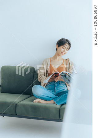 ソファーに座って読書をしている女性 106866997