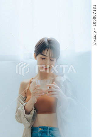 コップを持って窓辺にてくつろぐ女性 106867181