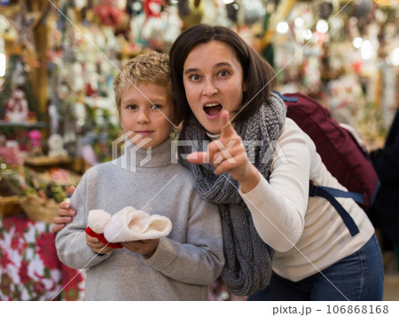 Surprised tween boy with mother at Christmas street market Surprised tween boy with mother at Christmas street market 106868168