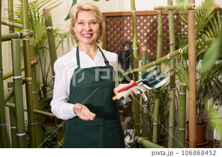 Florist with tools in floral shop. 106868452