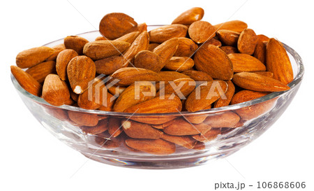 Handful of roasted almond nuts on a white surface 106868606