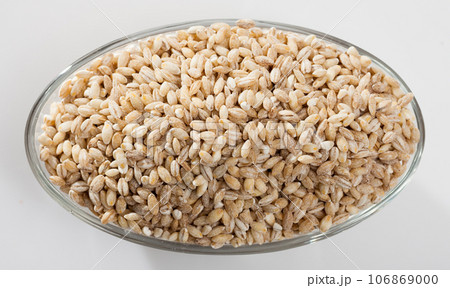Barley groats in glass bowl on white surface , nobody Barley groats in glass bowl on white surface , nobody 106869000