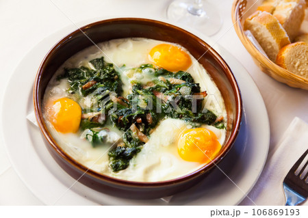 Fried eggs with spinach, ham, raisins Fried eggs with spinach, ham, raisins 106869193