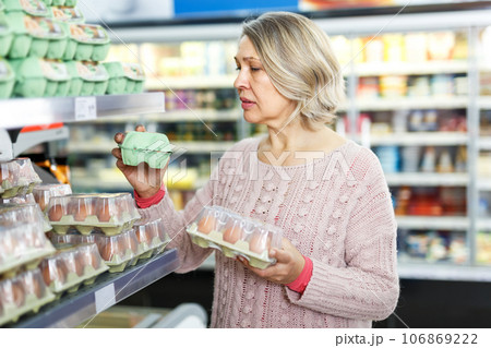 Woman buying eggs at grocery Woman buying eggs at grocery 106869222
