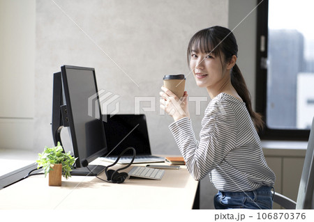 コーヒーを飲みながらパソコンを操作する女性 106870376