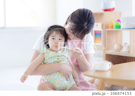 離乳食を食べている赤ちゃんと保育士 106874155
