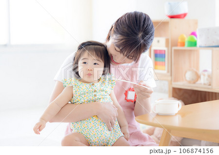 離乳食を食べている赤ちゃんと保育士 離乳食を食べている赤ちゃんと保育士 106874156