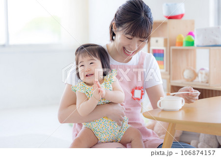 離乳食を食べている赤ちゃんと保育士 離乳食を食べている赤ちゃんと保育士 106874157