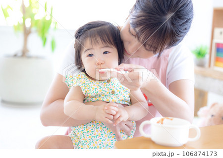 離乳食を食べている赤ちゃんと保育士 離乳食を食べている赤ちゃんと保育士 106874173