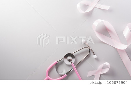 Pink ribbon and stethoscope on paper background for supporting breast cancer awareness month campaign. Pink ribbon and stethoscope on paper background for supporting breast cancer awareness month campaign. 106875904