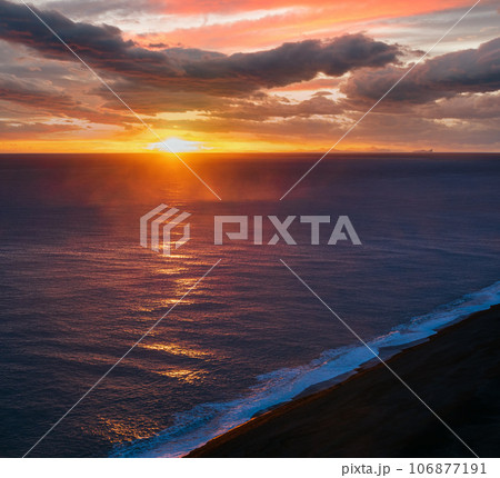 Picturesque autumn evening view to endless ocean  black volcanic sand beach from Dyrholaey Cape, Vik, South Iceland. Vestmannaeyjar islands weird silhouettes on horizont. 106877191