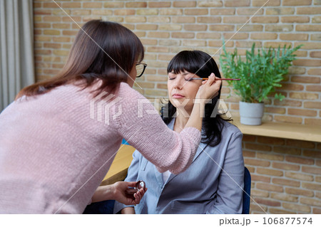 Makeup artist doing makeup for a mature business woman Makeup artist doing makeup for a mature business woman 106877574