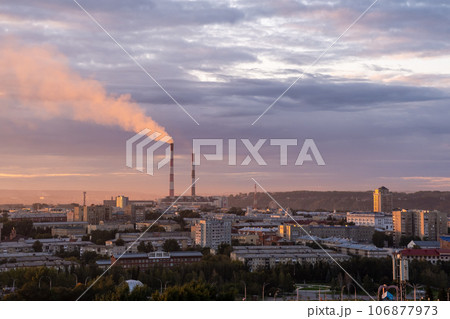 Beautiful urban area with houses and boiler room at sunset. View of the big city from above. Smoking chimneys of boiler rooms on the background of the cityscape 106877973