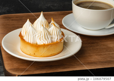Meringue tart with coffee cup on dark gray background Meringue tart with coffee cup on dark gray background 106879507
