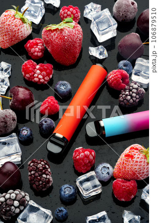 Electronic cigarette with berries and ice cubes on black background Electronic cigarette with berries and ice cubes on black background 106879510