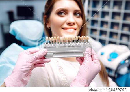 Young woman at the dentist's chair during a dental procedure. Overview of dental caries prevention. Young woman at the dentist's chair during a dental procedure. Overview of dental caries prevention. 106880795